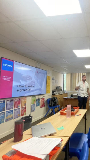 Professional CV writing training session in a classroom, featuring a presentation titled 'How to write a great CV,' with participants and materials prepared for career development in the construction industry.